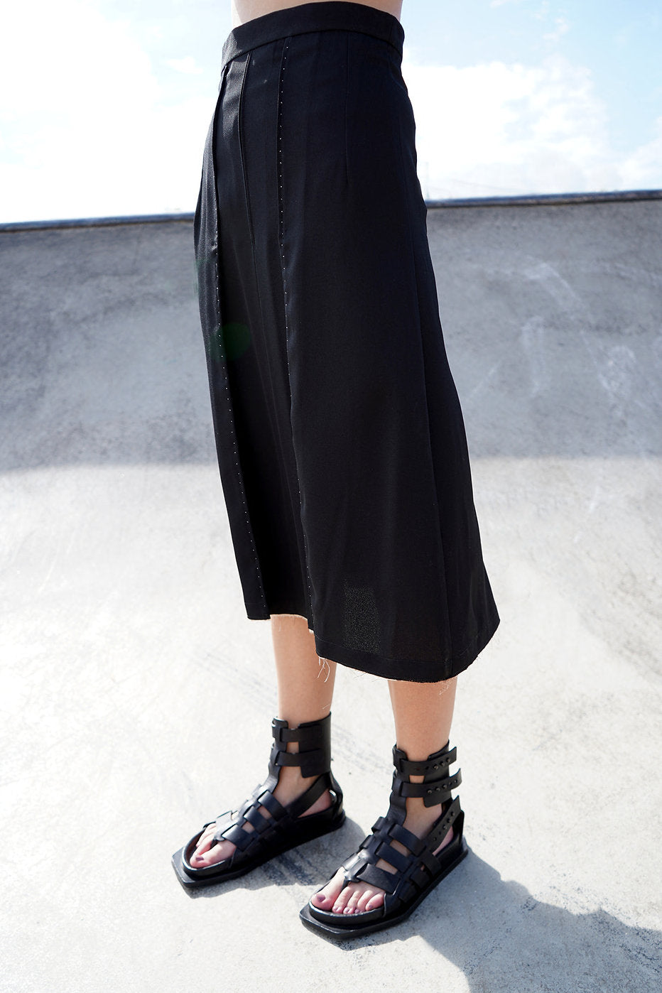 Side profile of the Amelia Midi Skirt, showing the metal zip and pleated fabric.