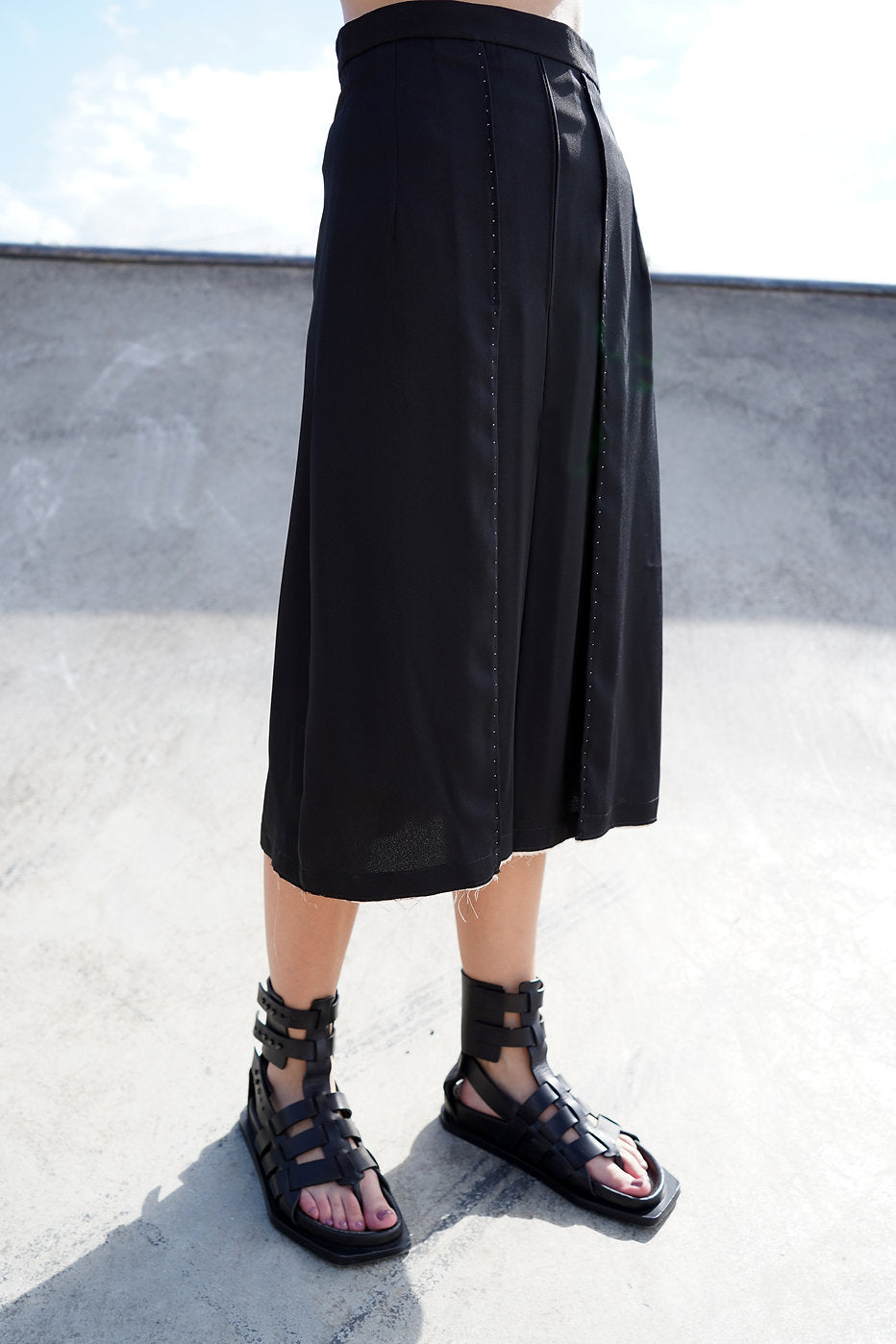 Detailed view of the raw hem and contrast binding on the black Amelia Midi Skirt.