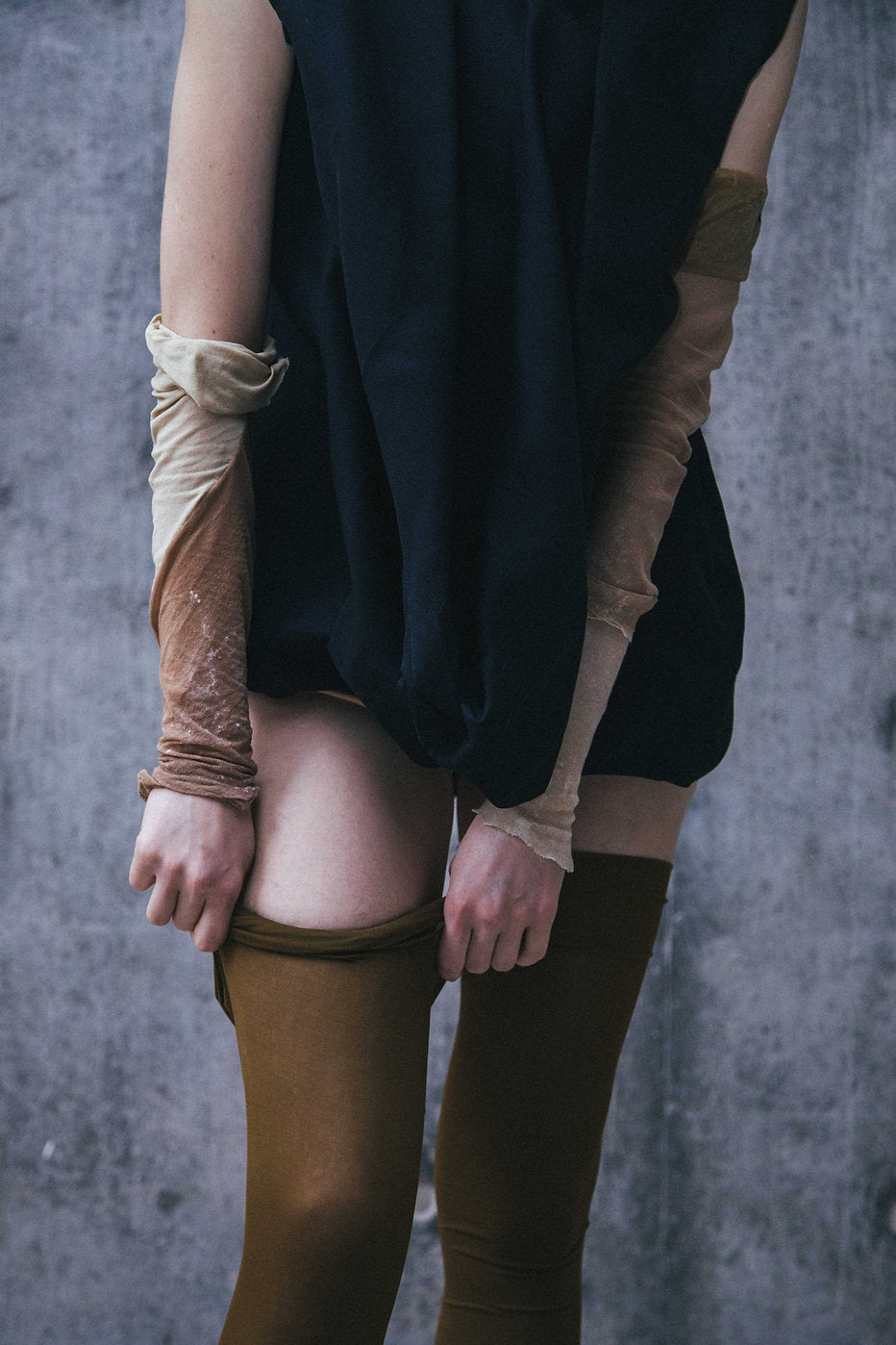 Model wearing Winnie Witt's black Deconstructed Dress, featuring a distinctive cowl neckline and convertible calf sleeves.