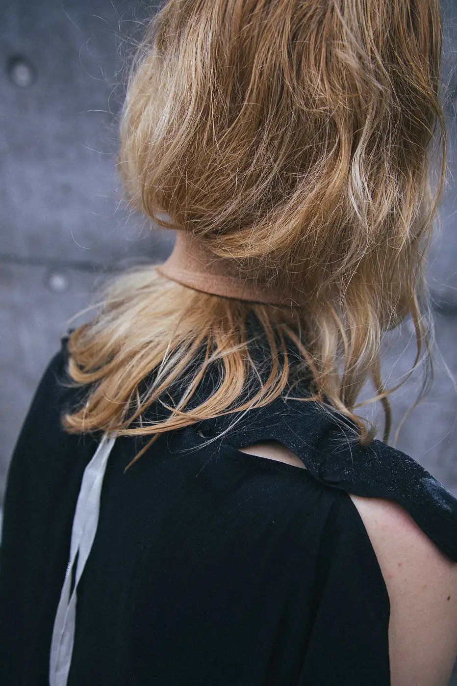 Sophisticated black dress featuring a unique deconstructed style with a metal zipper at the back.