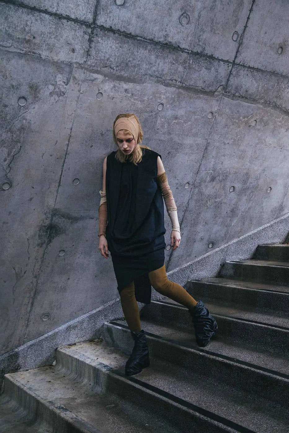 Black Deconstructed Dress with cowl neckline and convertible sleeves, displayed on a model.