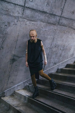 Black Deconstructed Dress with cowl neckline and convertible sleeves, displayed on a model.